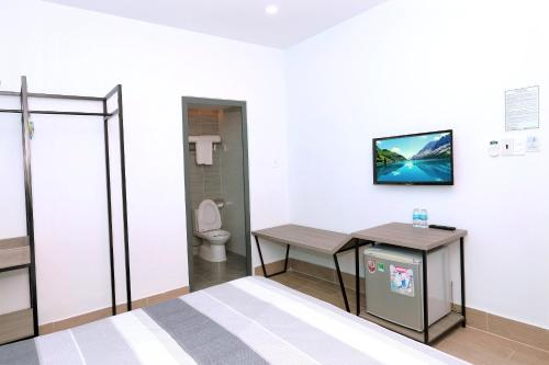 a room with a bed and a table and a toilet at HÀO PHÁT HOTEL NHA TRANG in Nha Trang