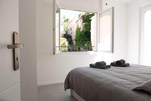 une chambre avec un lit avec deux serviettes dessus dans l'établissement T4 moderne à 2 min de la plage, à Banyuls-sur-Mer