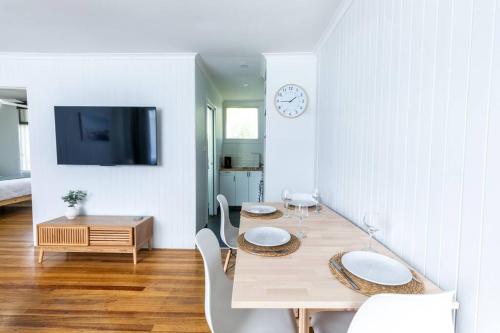 a dining room with a table and chairs and a tv at Orton Waves- Beach Life Awaits in Ocean Grove