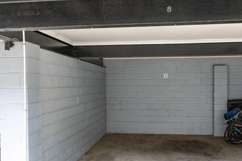 a garage with white brick walls and a ceiling at Orton Waves- Beach Life Awaits in Ocean Grove