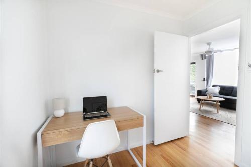 a room with a desk with a laptop on it at Orton Waves- Beach Life Awaits in Ocean Grove