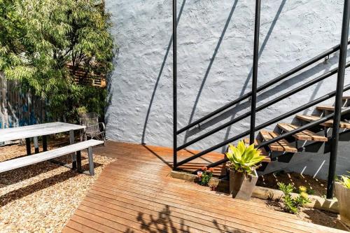 a wooden deck with a bench and a staircase at Orton Waves- Beach Life Awaits in Ocean Grove