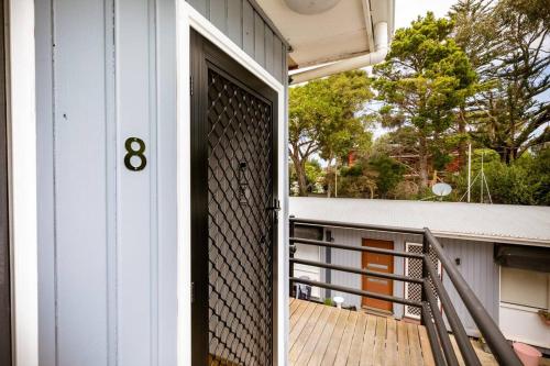 an open door of a house with a balcony at Orton Waves- Beach Life Awaits in Ocean Grove