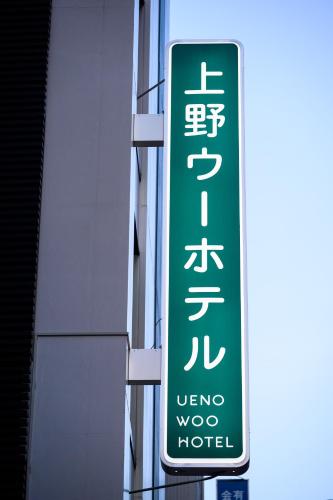 a sign for a visitor motel on the side of a building at Ueno Woo Hotel in Tokyo