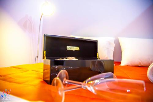 a pair of glasses and a box on a bed at Liberte Maisonettes in Parga