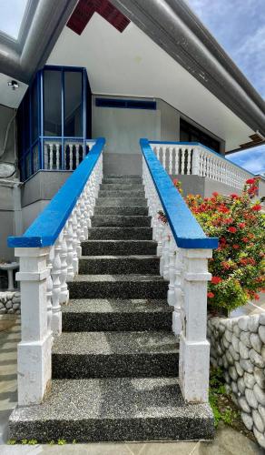a staircase leading to a house with blue benches at Ngermid Oasis - Studio W/ Kitchenette & Pool View in Koror