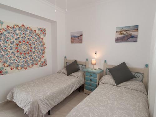 1 dormitorio con 2 camas y mesita de noche azul en CASA APARTAMENTO TERRAZAS DE ALGODONALES, en Algodonales