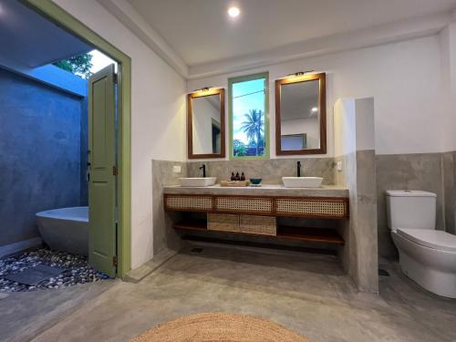 łazienka z 2 umywalkami, wanną i toaletą w obiekcie Zen House w mieście Ahangama