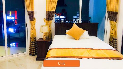 a bedroom with a bed with an orange and yellow pillow at Ivory Laze Hotel in Negombo