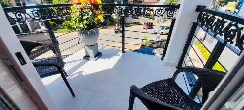 a balcony with two chairs and a vase with a plant at Ivory Laze Hotel in Negombo