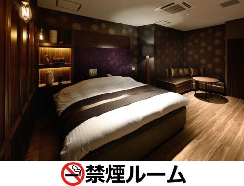 a bedroom with a large bed and a desk at Hotel LALA - Kitashiga - (Adult Only) in Nagoya