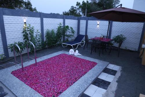 a patio with pink flowers and a table and an umbrella at SKD RESORT AND CLUB in Barvāla