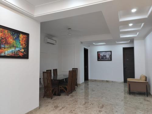 a dining room with a table and a painting on the wall at The Hoften Elite 32 Avenue, Sector 15, Gurugram in Gurgaon