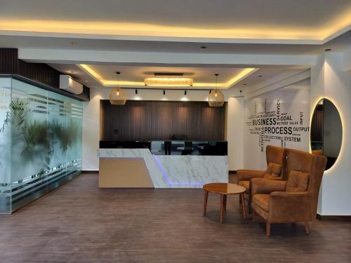 a waiting room with a chair and a table at The Hoften Elite 32 Avenue, Sector 15, Gurugram in Gurgaon