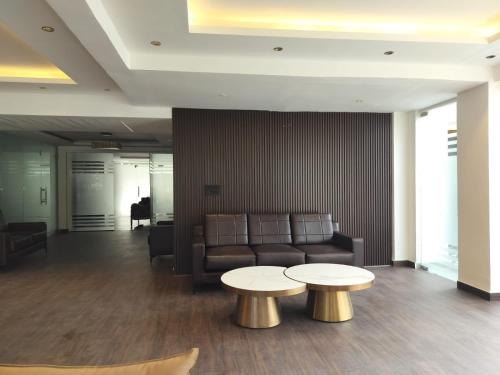 a living room with a couch and two tables at The Hoften Elite 32 Avenue, Sector 15, Gurugram in Gurgaon