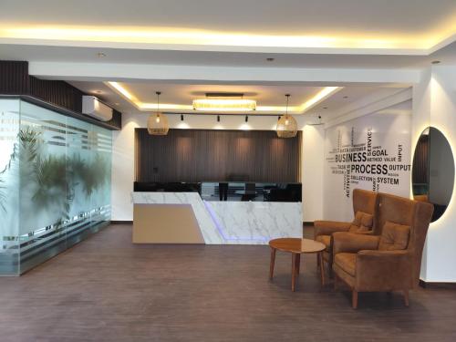 a waiting room with a chair and a table at The Hoften Elite 32 Avenue, Sector 15, Gurugram in Gurgaon
