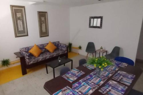 ein Wohnzimmer mit einem Sofa und einem Tisch in der Unterkunft Refugio Amarelo en calle 10: eje vital de la zona in Ciudad Madero