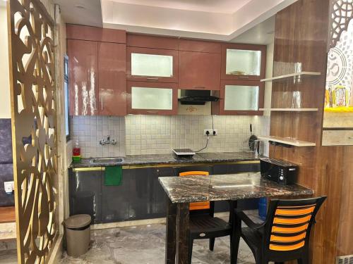 a kitchen with a table and some chairs at Tripur Sundari Nilaya in Vrindāvan