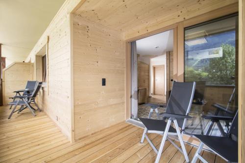 a room with wooden flooring and chairs in a house at Hotel Pramstraller in Mayrhofen