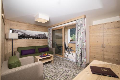 a living room with a couch and a table at Hotel Pramstraller in Mayrhofen