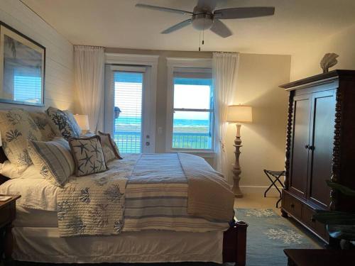 Schlafzimmer mit einem Bett und einem Deckenventilator in der Unterkunft Unobstructed Beachfront Views at Private Beachfront Resort in Galveston