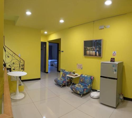 a room with two chairs and a table and yellow walls at Bei Ao Bi Shan Jyu in Dongyin