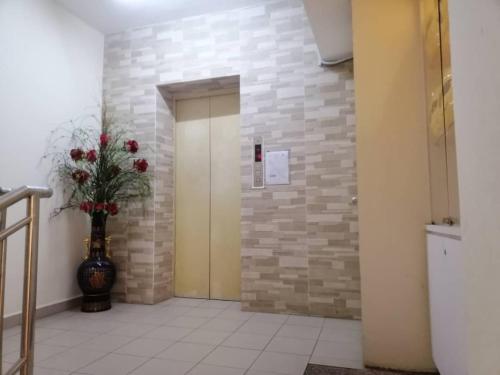 korytarz z wazonem kwiatów i drzwiami w obiekcie Seeds Hotel Cheras Taman Bukit Segar w mieście Cheras
