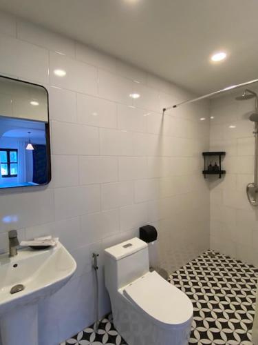 a bathroom with a white toilet and a sink at Fides Boutique Hotel in Luang Prabang