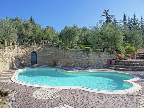einen Pool in einem Hof mit Ziegelwand in der Unterkunft Apartment in quiet and green environment with swimming pool in Modigliana