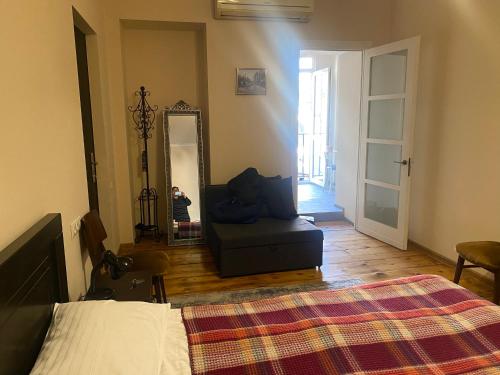 a bedroom with a bed and a mirror and a chair at my house in Tbilisi City