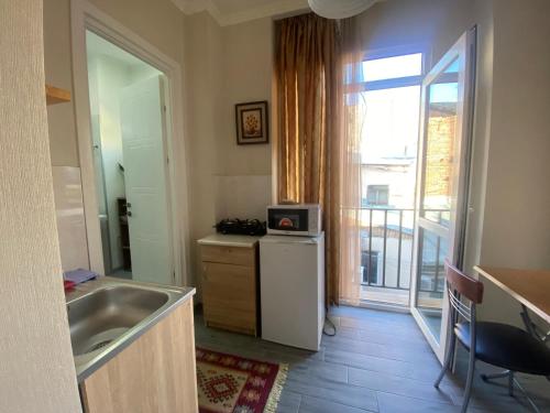 een keuken met een wastafel, een koelkast en een raam bij my house in Tbilisi City