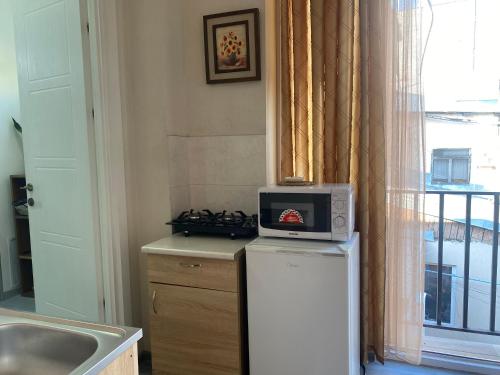 a kitchen with a microwave on top of a refrigerator at my house in Tbilisi City