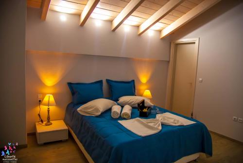a bedroom with a blue bed with two pillows at Liberte Maisonettes in Parga