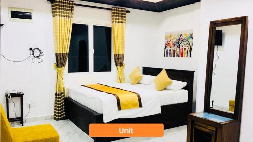 a bedroom with a bed and a mirror with an orange box at Ivory Laze Hotel in Negombo