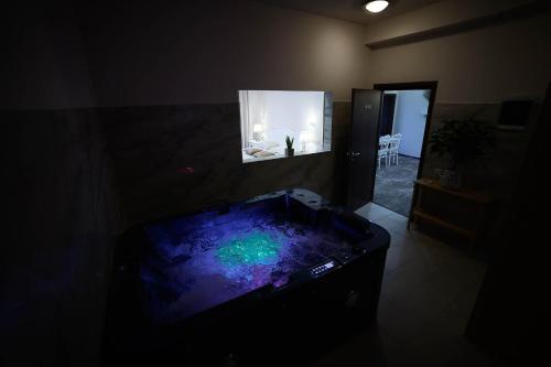 ein dunkles Zimmer mit einer Badewanne in einem Zimmer mit einem Spiegel in der Unterkunft Hotel Secret Garden in Baia Sprie