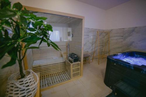 a room with a tub and a plant in it at Hotel Secret Garden in Baia-Sprie