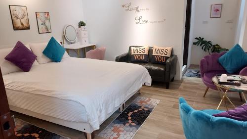 a bedroom with a large bed and two chairs at Youngnn Hostel in Lugang