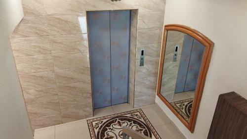 a bathroom with a walk in shower next to a mirror at Smile Hotel Serdang South City in Serdang