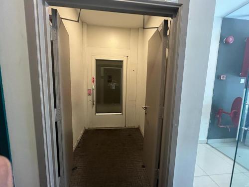 un corridoio con porta che conduce a una camera di Smile Hotel Subang Airport a Shah Alam