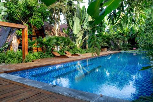 a swimming pool in a garden with a wooden deck at Tiên Sơn Pleiku Homestay in Pleiku