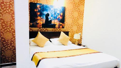 a bedroom with a bed and a painting on the wall at Ivory Laze Hotel in Negombo