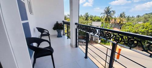 a balcony with chairs and a view of a garden at Ivory Laze Hotel in Negombo