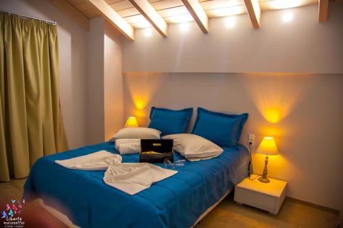 a blue bed in a room with two lamps at Liberte Maisonettes in Parga