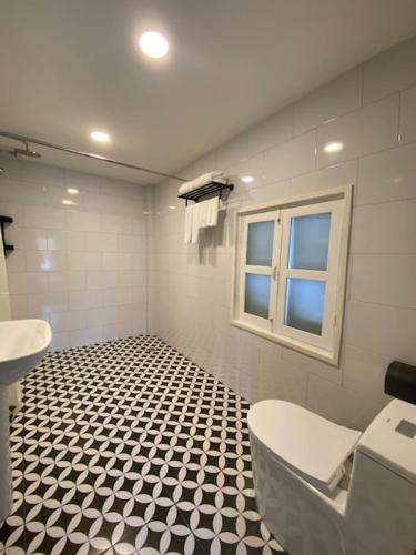 a bathroom with a black and white tiled floor at Fides Boutique Hotel in Luang Prabang
