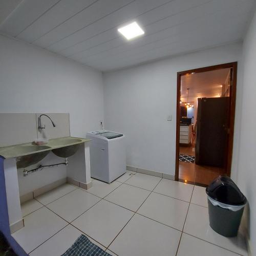 a white kitchen with a sink and a counter at Residência Thomas in Itacaré