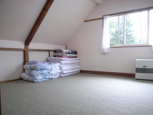 Zimmer im Dachgeschoss mit einem Haufen Decken in der Unterkunft Cottage All Resort Service / Vacation STAY 8407 in Inawashiro