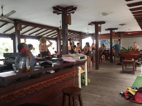 a group of people sitting at a bar in a restaurant at MR Mo Guest House in Muang Không