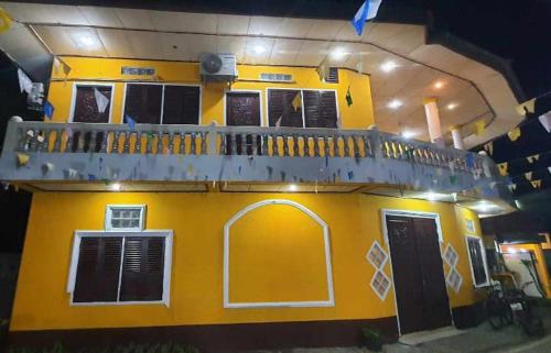 a yellow house with a balcony on top of it at MR Mo Guest House in Muang Không