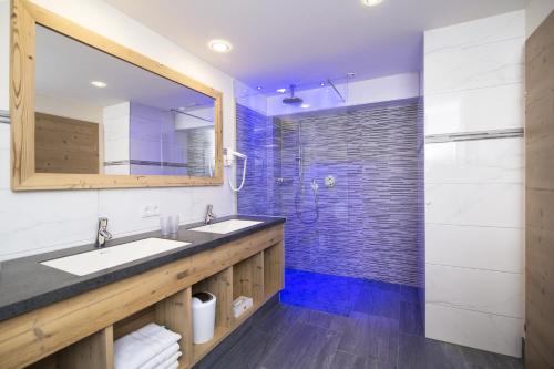 a bathroom with two sinks and a shower at Hotel Pramstraller in Mayrhofen