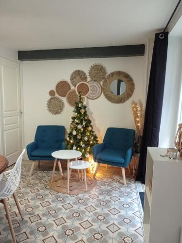 a christmas tree in a living room with two chairs and a table at Gîte Quai N 10 in Saint-Valéry-en-Caux